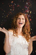 Confetti falling on celebrating Caucasian woman