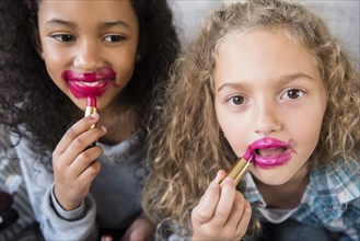 Girls applying messy lipstick