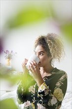 Mixed Race woman drinking coffee