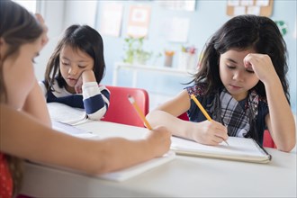 Girls writing in notebooks in school