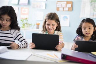 Girls using digital tablets in classroom