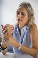 Caucasian woman rubbing hand in pain
