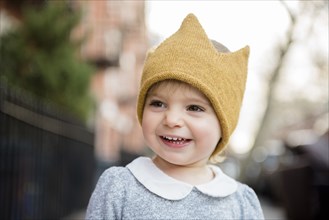 Smiling Caucasian baby girl wearing crown hat