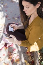 Caucasian woman online shopping with cell phone in autumn
