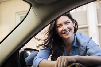 Smiling Caucasian woman leaning in car window