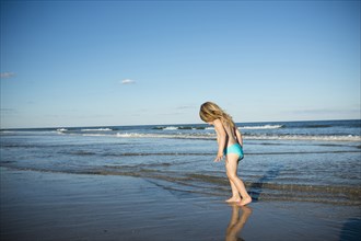 Caucasian girl walking on beach