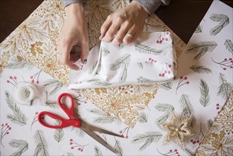 Hands of Caucasian woman wrapping Christmas gifts