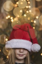 Caucasian girl wearing large Santa hat