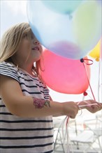 Caucasian girl holding multicolor balloons