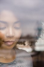 Pensive African American woman behind window