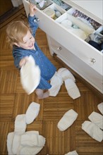 Caucasian girl throwing diapers on floor