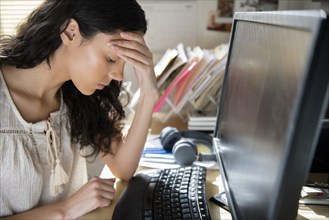 Frustrated Hispanic woman using computer