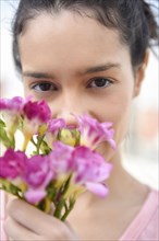 Close up of Hispanic woman holding flowers