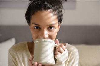 Hispanic woman drinking coffee
