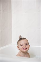 Smiling Caucasian girl in bubble bath