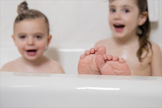 Smiling Caucasian girls in bathtub