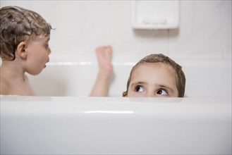 Caucasian girl peaking from bathtub