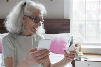 Older woman checking prescription with cell phone