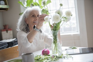 Older woman arranging flowers