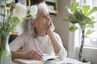 Pensive older woman writing in journal