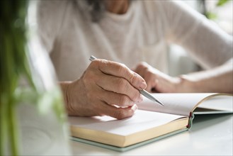 Hands of older woman writing in journal