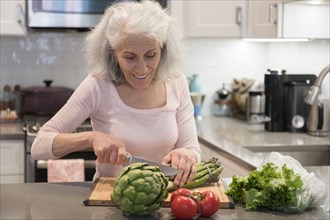 Older woman chopping asparagus
