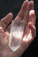 Hand of Caucasian woman holding crystal