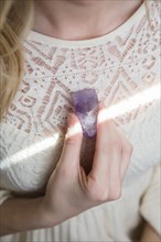 Caucasian woman holding crystal to heart