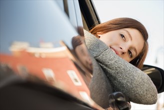 Caucasian woman leaning out car window