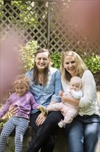 Portrait of smiling Caucasian mothers and daughters in garden