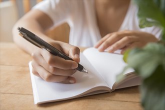 Hands of African American woman writing in journal