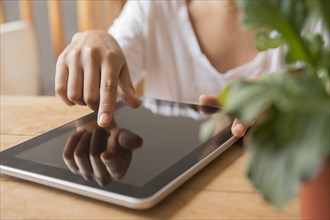 Hands of African American woman using digital tablet