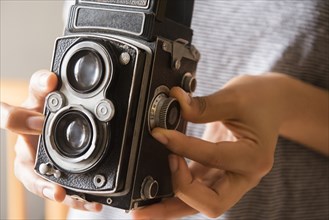 Hands of African American woman using old-fashioned camera