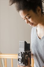 African American woman using old-fashioned camera