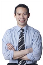 Smiling Chinese businessman with arms crossed