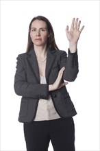Serious Caucasian businesswoman with arms raised