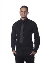 Smiling Hispanic businessman with hands in pockets