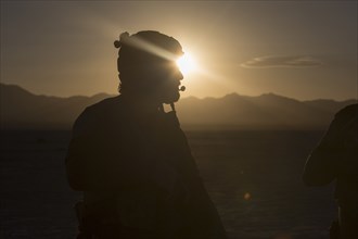 Silhouette of soldier standing in desert landscape