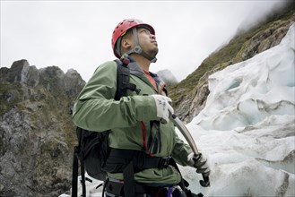 Chinese man looking up at glacier
