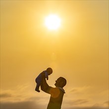 Profile of father holding baby son