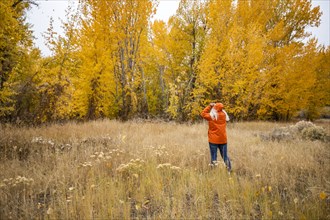 Rear view of woman in grassy meadow in Autumn
