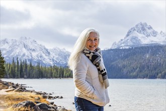 Portrait of smiling senior woman at mountain lake