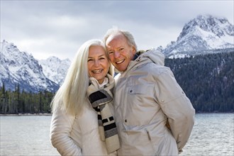 Portrait of smiling senior couple at mountain lake