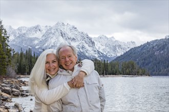 Portrait of smiling senior couple at mountain lake