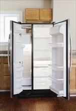 Empty open fridge in domestic kitchen