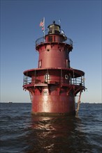 Red lighthouse in sea
