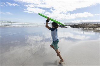 Boy with surfboard on beach