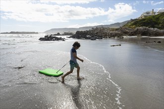 Boy with surfboard on beach