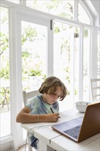 Boy drawing picture during online lesson