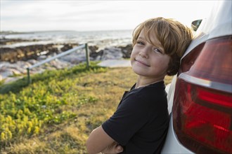 Portrait of Boy leaning on SUV